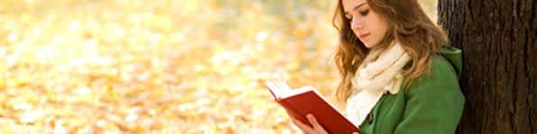 Girl reading book outdoors