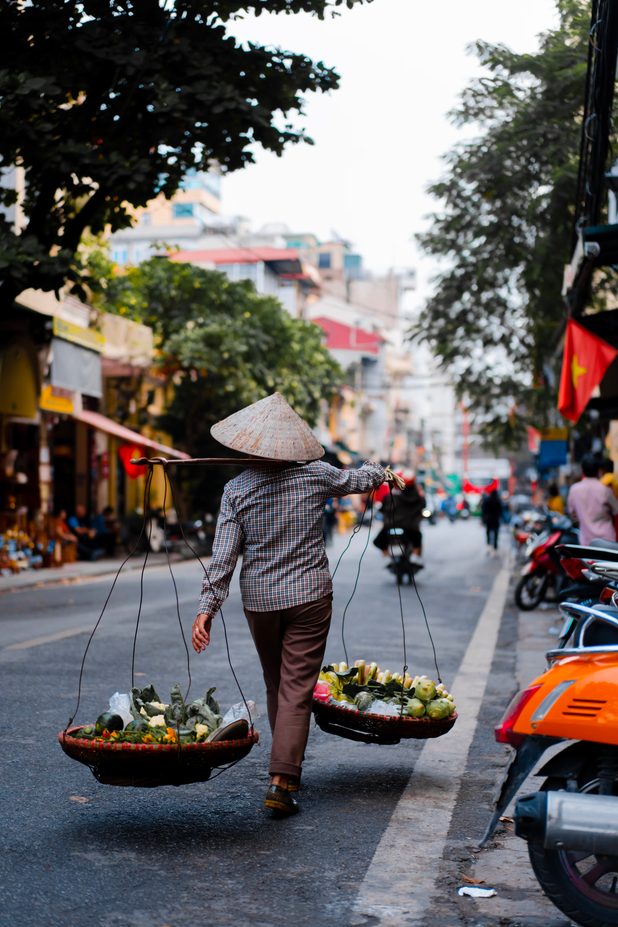 Vânzătoare cu coșuri pe o stradă din Hanoi