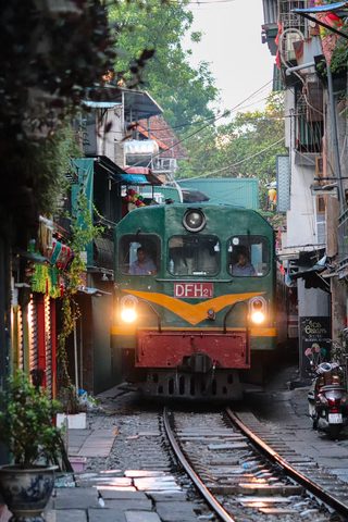 Trenul care trece printre case, pe o stradă din Hanoi